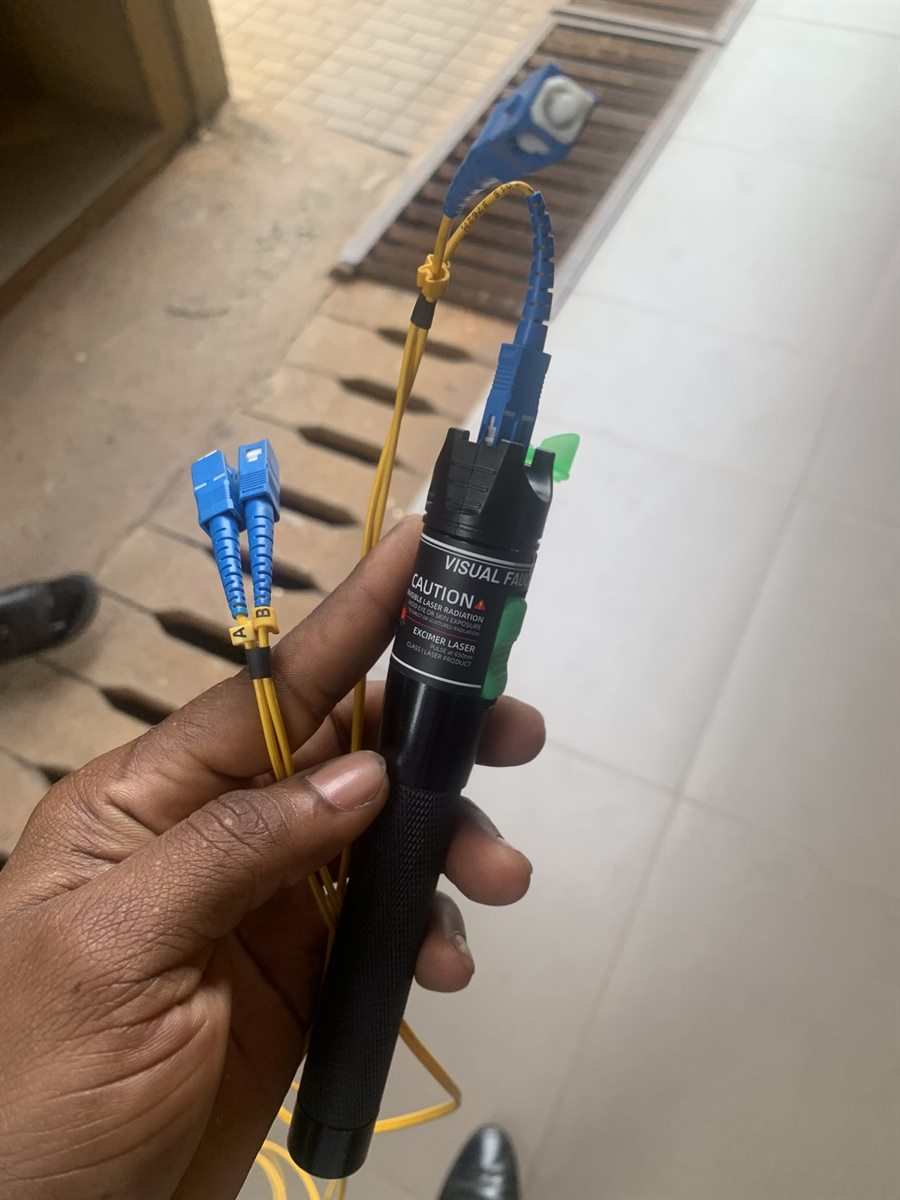 Fiber patch leads connected to a visual fault locator during testing.