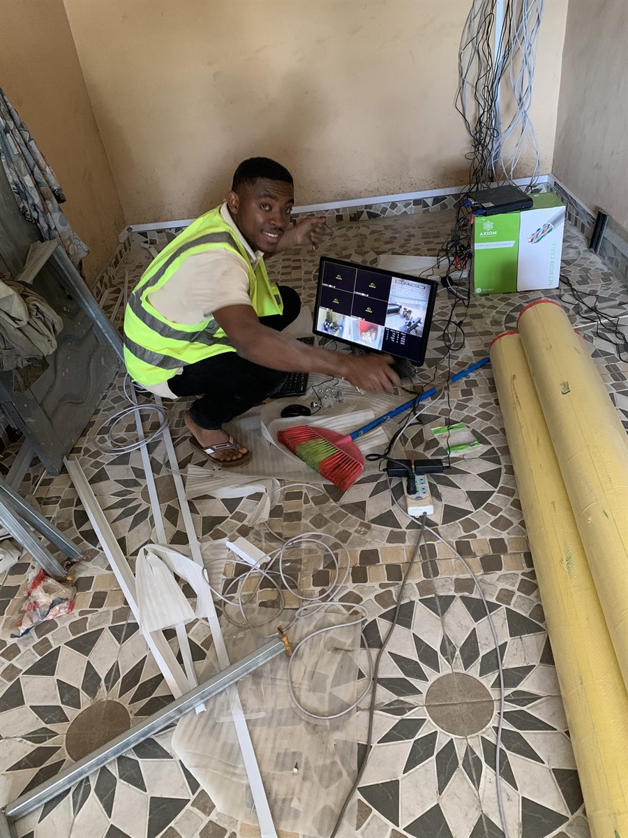 Technician configuring network equipment with a laptop on site.