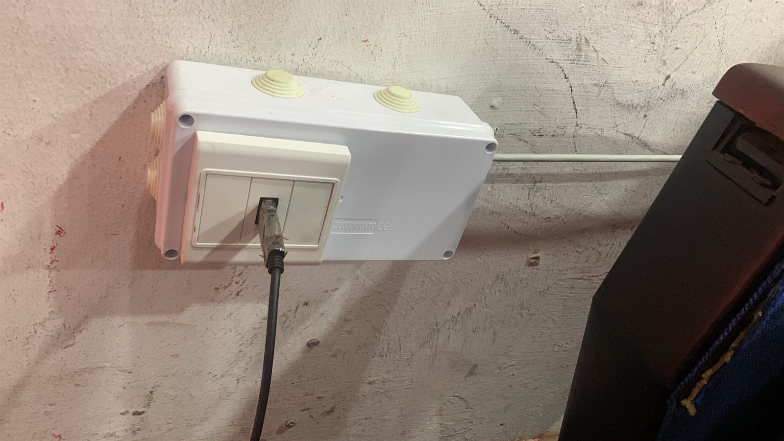 Wall-mounted network box and cable on a finished installation.